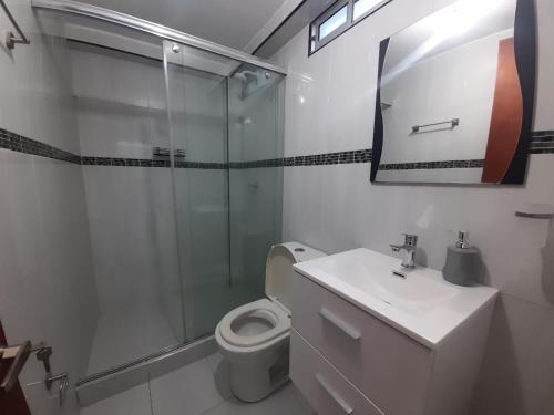 een badkamer met een douche, een toilet en een wastafel bij Casa Numbana in Norcasia
