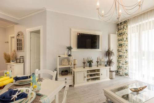 a living room with a table and a tv at Apartament La Plaja in Mamaia Nord