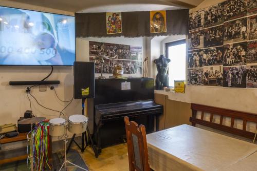 a room with a piano and a table and a screen at mlyn-osvracin in Osvračín