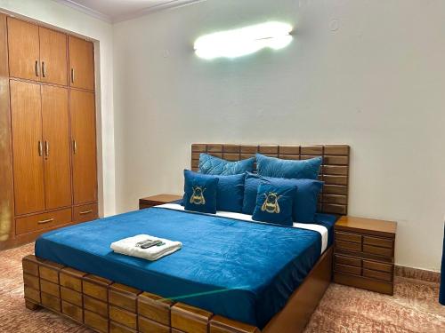 a bedroom with a bed with blue sheets and blue pillows at Entire flr 2BHK+terrace near Medanta hospital ggn in Gurgaon
