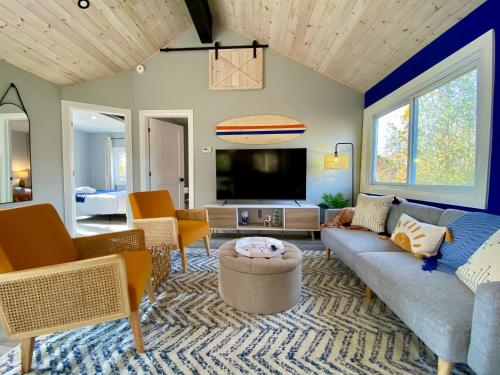 sala de estar con sofá y TV en Creekside Cottage - kayak/SUP, fishing, game room en Kingsville