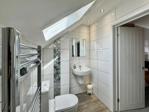 a bathroom with a toilet and a sink and a window at Waterloo House - Urban Oasis Townhouse in Nottingham