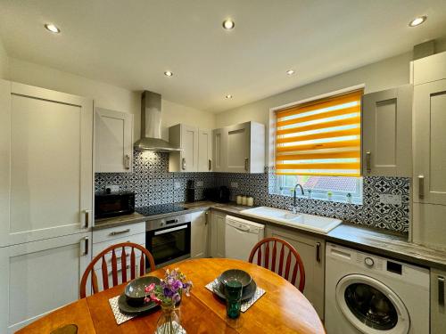 a kitchen with a wooden table and a sink at Waterloo House - Great for Contractors or Family Holidays in Nottingham