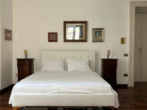 a bedroom with a large white bed with two night stands at Palazzo Quey in Lecce