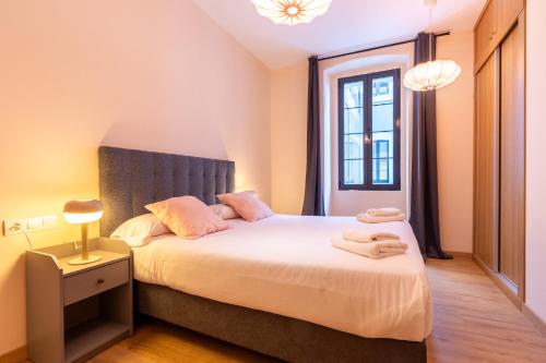 1 dormitorio con 1 cama con 2 toallas en INSIDEHOME Ciudad de Avilés en Avilés