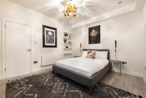 1 dormitorio con cama y lámpara de araña en Charming Euston en Londres