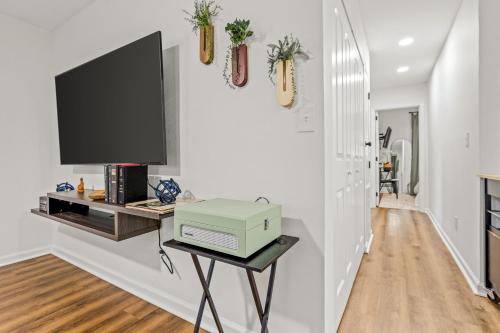 a living room with a tv on a wall at Midtown CharmMinutes to Downtown, FSU, FAMU in Tallahassee