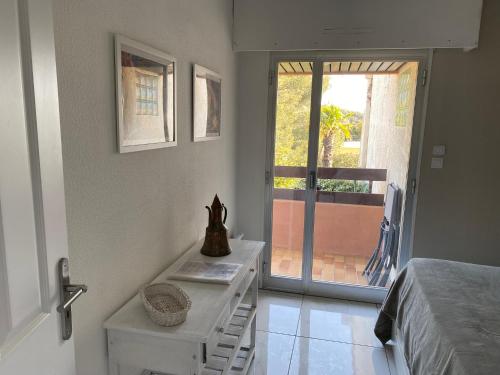 een slaapkamer met een bed, een tafel en een raam bij Appartement Cosy à Sanary Plage de Portissol-Climatisé-Parking privé in Sanary-sur-Mer