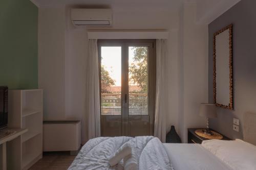 a bedroom with a bed and a sliding glass door at Lazarus 2BD Apartment in the Center in Patra