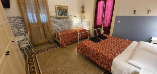 a hotel room with two beds and a window at Affittacamere Museo in Taranto