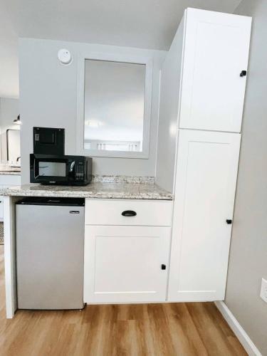 a kitchen with white cabinets and a microwave at Mountain Explorer's Haven in Townsend