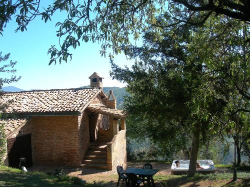 a brick building with a table and chairs in a yard at Agriturismo Cuore Verde La Madreselva a Spello in Spello