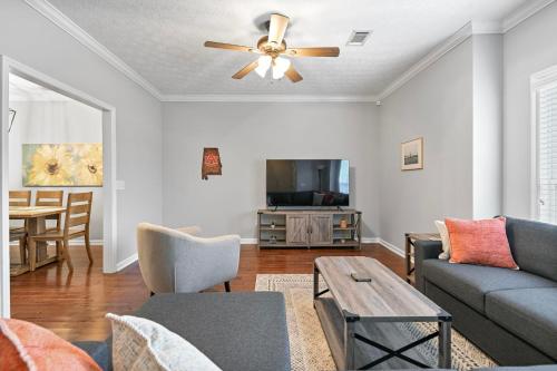 a living room with a couch and a ceiling fan at Tiger's Den On Dean In Auburn in Auburn