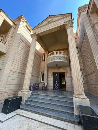 un edificio con columnas y escalones delante de una puerta en VIP Villa فيلا فاخرة, en Sheikh Zayed