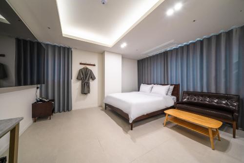 a hotel room with a bed and a couch at Bluebird Hotel in Incheon