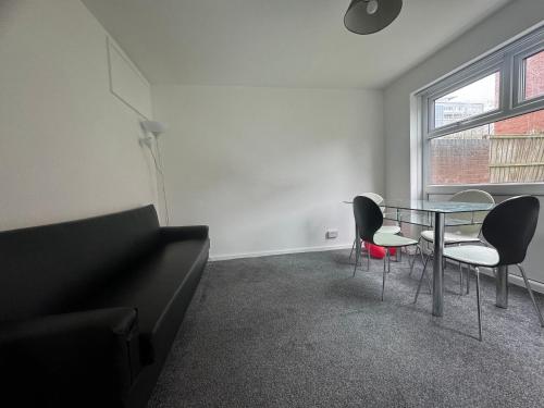 a living room with a glass table and chairs at Homestay-Close to Coventry City and University I Free Parking I Wi-Fi in Coventry