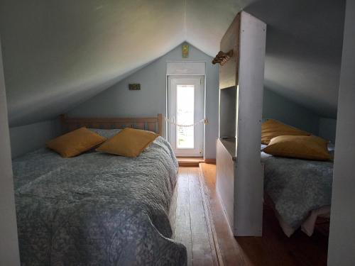 a bedroom with two beds and an open door at LE DOMAINE DU HIBOU 