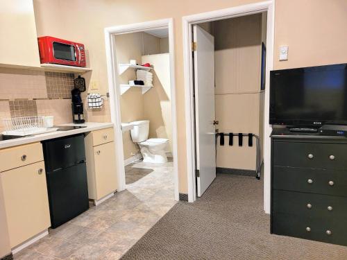 a small kitchen with a sink and a toilet at Lido Motel in Radium Hot Springs