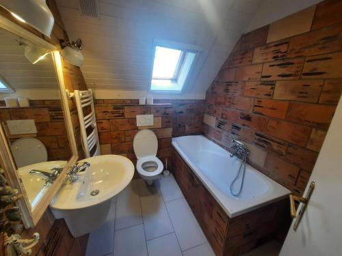 uma casa de banho com um WC, uma banheira e um lavatório. em Tánczos Pince Vendégház em Zánka