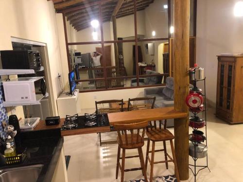 a kitchen with a counter and some chairs in a room at Belíssima casa no condomínio Mar Doce de Abrolhos in Caravellas