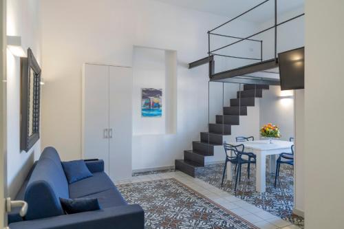 a living room with a blue couch and a table at Le Suite del Castello in Castellammare di Stabia
