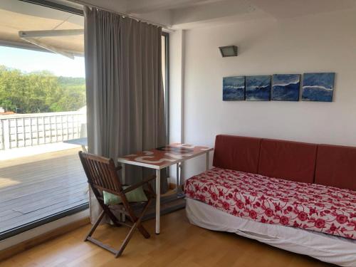 um quarto com uma cama, uma mesa e uma janela em Disfruta del Montseny em Santa María de Palautordera