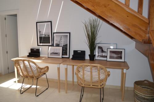 einen Esstisch mit 2 Stühlen und Bildern an der Wand in der Unterkunft Villa Tegala in Playa Blanca