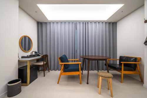 a room with chairs and a table and a window at Bluebird Hotel in Incheon
