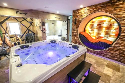 eine Whirlpool-Badewanne in der Mitte eines Zimmers in der Unterkunft Appartement d'une chambre avec piscine privee sauna et wifi a Montbeliard in Montbéliard