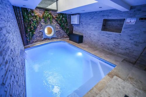 une piscine avec des toilettes dans un mur de briques dans l'établissement Appartement d'une chambre avec piscine privee sauna et wifi a Montbeliard, à Montbéliard