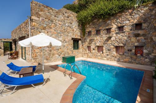 a swimming pool with two chairs and an umbrella at Seaview villa Amphitriti with Private Pool, 20 min from Elafonissi beach in Chania
