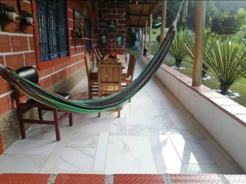 a hammock on the porch of a house at Finca privada Monte sol para 15 personas in La Pintada