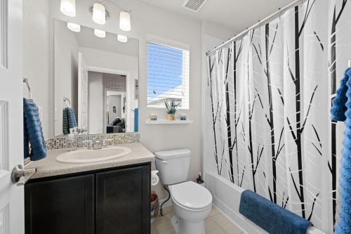 a bathroom with a toilet and a sink and a mirror at Uptown Avenue - Broomfield in Broomfield