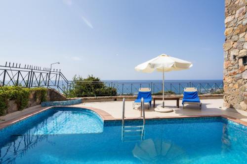 a swimming pool with an umbrella and two chairs and a table and an umbrella at Seaview villa Amphitriti with Private Pool, 20 min from Elafonissi beach in Chania