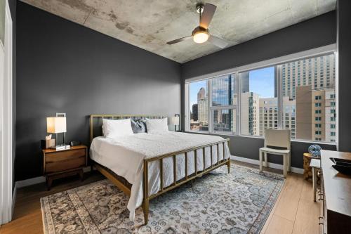 1 dormitorio con cama y ventana grande en Spire - Unit 1810, en Denver