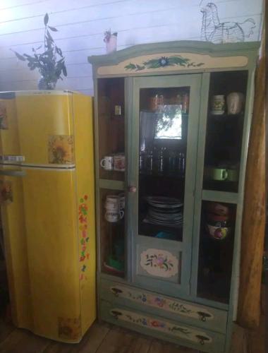 a green cabinet next to a yellow refrigerator at Cabaña Gaia in Los Cocos