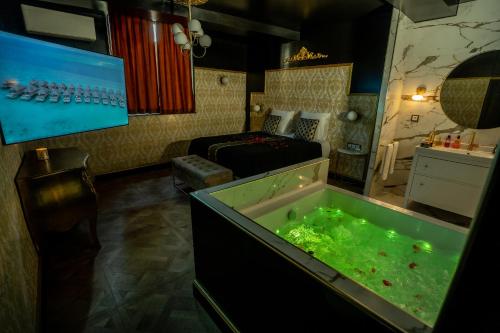 a room with a large tub filled with green water at Appartement d'exception avec Jacuzzi in Villefranche-sur-Saône