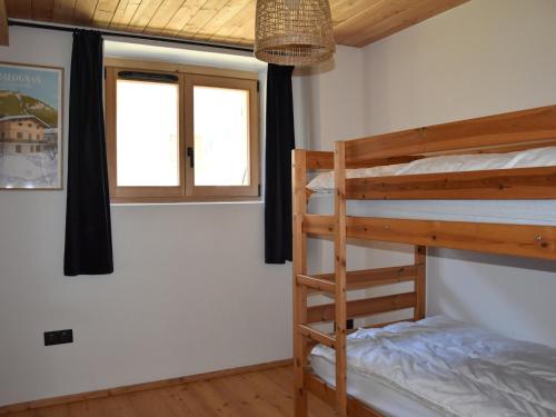 une chambre avec deux lits superposés et une fenêtre dans l'établissement Rez-de-jardin ensoleillé, 3 pièces, proche centre et pistes, animaux acceptés - FR-1-464-206, à Pralognan-la-Vanoise