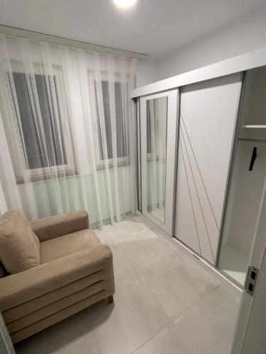 a living room with a chair and a sliding glass door at Bany’s Apartment in Peje