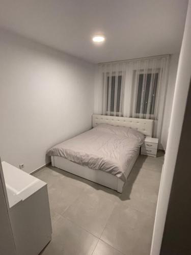 - une petite chambre blanche avec un lit et un lavabo dans l'établissement Bany’s Apartment, à Peje