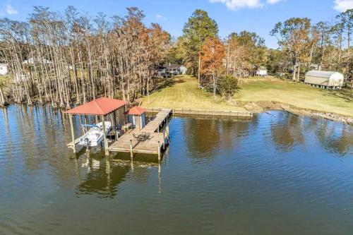 a dock on a lake with a boat on it at Cypress Grove - Dog River in Mobile