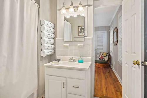 a white bathroom with a sink and a mirror at Cypress Grove - Dog River in Mobile