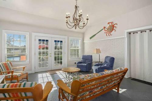 a living room with a couch and chairs and a chandelier at Cypress Grove - Dog River in Mobile