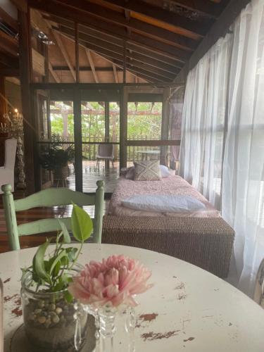 Un dormitorio con una cama y una mesa con una flor. en Jinwhi, en Beechmont