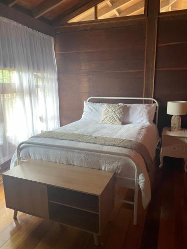 1 dormitorio con 1 cama con mesa y ventana en Jinwhi, en Beechmont