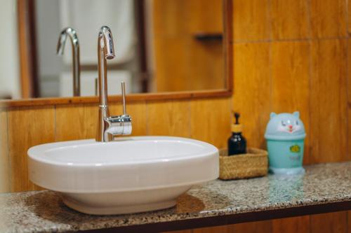 lavabo blanco en el baño con espejo en Edelwyss-Inn en Morogoro