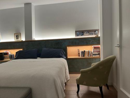 ein Schlafzimmer mit einem Bett und einem Stuhl in der Unterkunft Luxury Village Attic and Suite in my Shared Home in Tiana