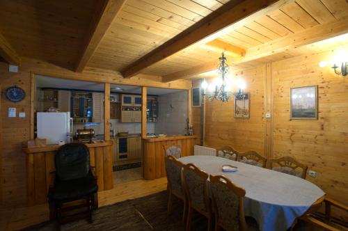 kuchnia i jadalnia ze stołem i krzesłami w obiekcie Brvnara Bjelasica w mieście Kolašin