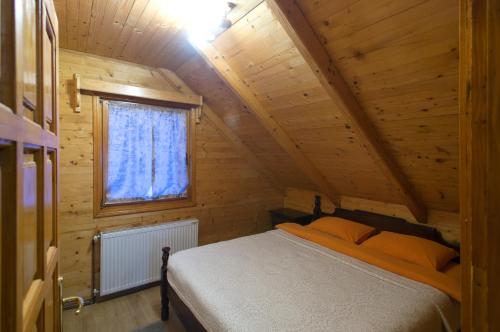 ein Schlafzimmer mit einem Bett in einer Holzhütte in der Unterkunft Brvnara Bjelasica in Kolašin