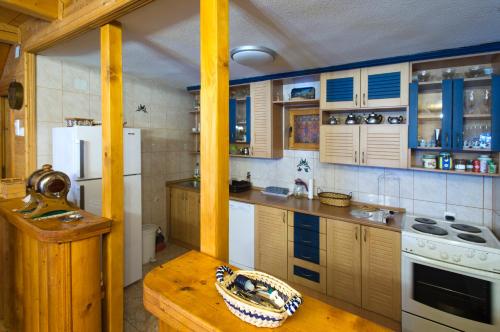 a kitchen with wooden cabinets and a white refrigerator at Brvnara Bjelasica in Kolašin